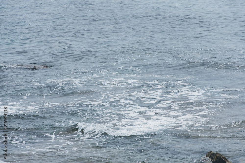 Fototapeta premium Coast. Sea waves. Stone beach. Mediterranean Sea. Water splashes. Place for inspiration. Background for travel company. Rest on the sea.