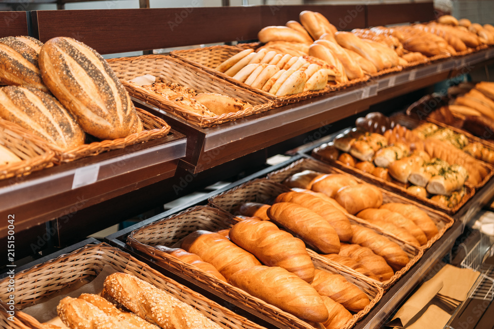 selective focus of freshly baked various bread in pastry department of supermarket