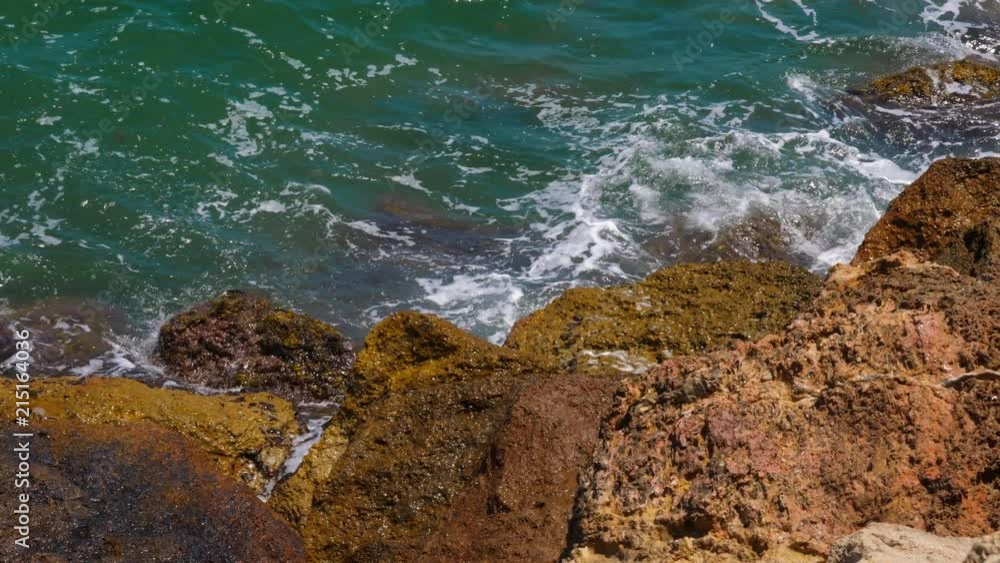 Sea waves splashing about big stones on shore top view Sea waves splashing about big stones on shore top view