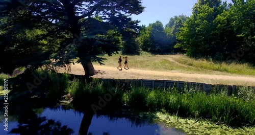 People walk and camera ascends, Wanstead Park in London, Drone footage. photo