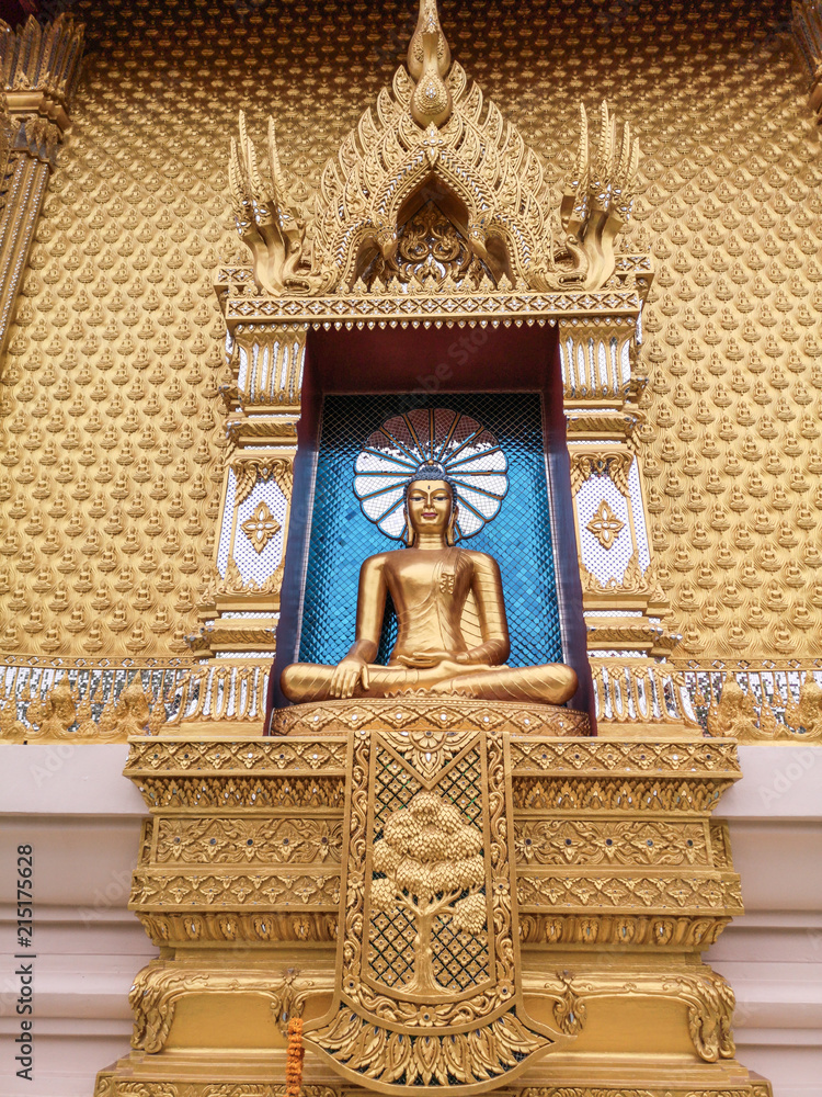 Beautiful gold Buddha statue in lotus position with amazing blue background