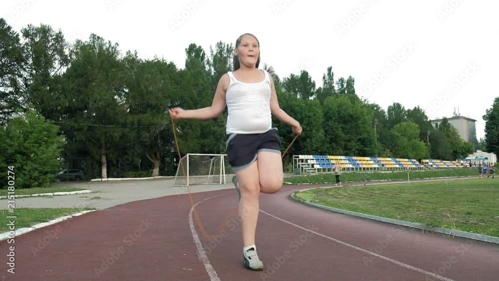 Little fat girl jumping rope in the stadium Little fat girl jumping rope in the stadium