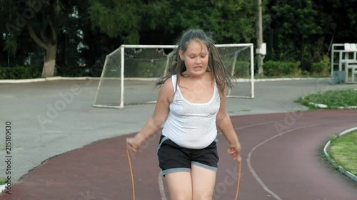 Little fat girl jumping rope in the stadium