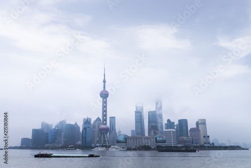 Shanghai Financial Center and modern skyscraper city in misty sunrise behind pollution haze, view from the bund in Shanghai, China. vintage picture style