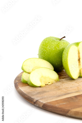 Green apple slices on a wooden cutting board, white background isolated. Concept vitamin C in the fruit.