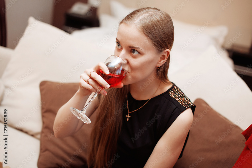 Beautiful young woman with glass of wine relaxing at home Beautiful young woman with glass of wine relaxing at home