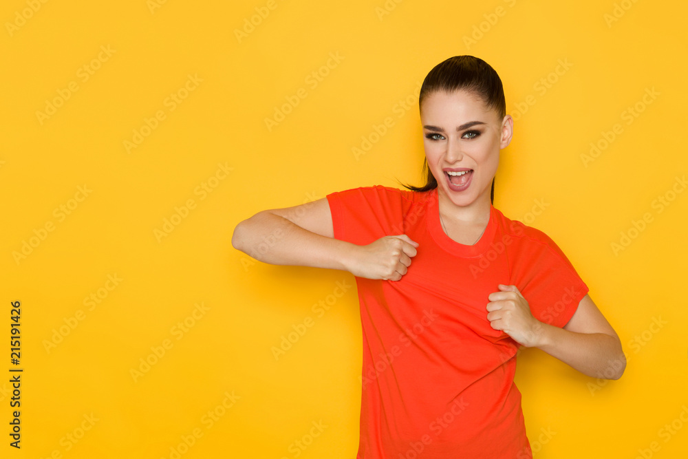 Young Woman Is Stretching Her Orange Shirt And Shouting Young Woman Is Stretching Her Orange Shirt And Shouting