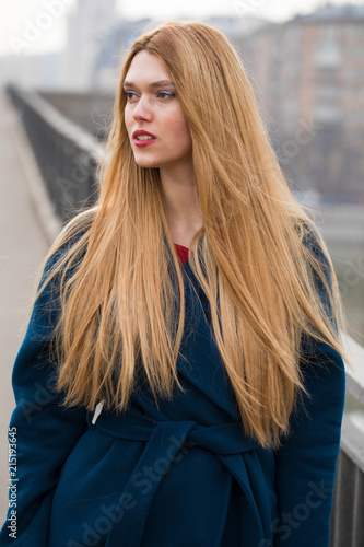 Portrait of a young beautiful woman in blue coat