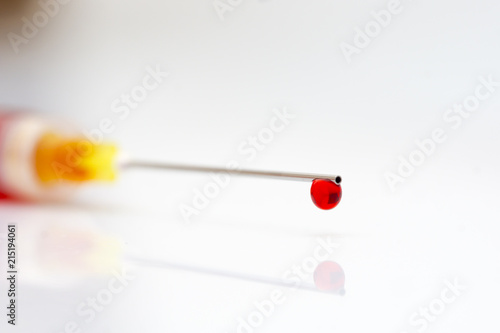 close up blood drops from the tip of the injection needle