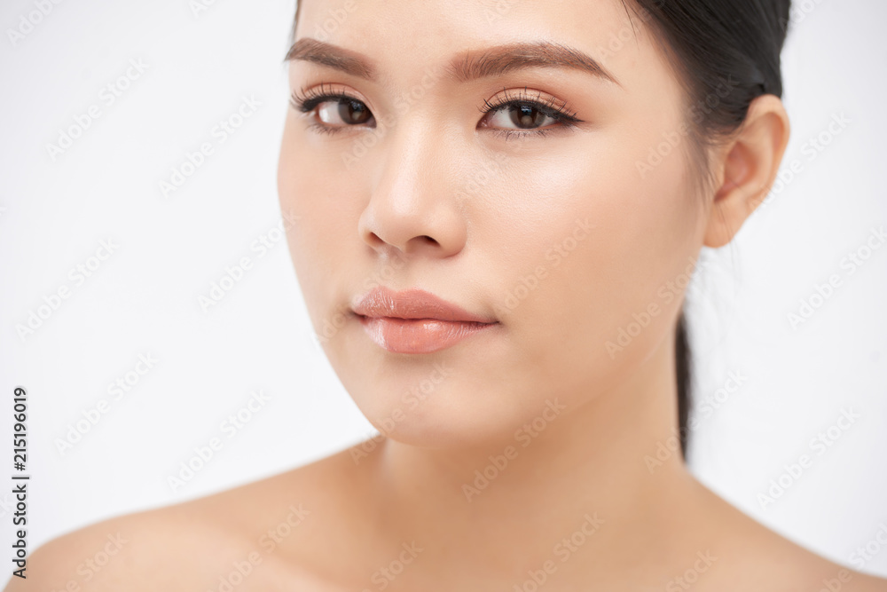 Young pretty Asian woman with clear skin looking at camera on white background Young pretty Asian woman with clear skin looking at camera on white background