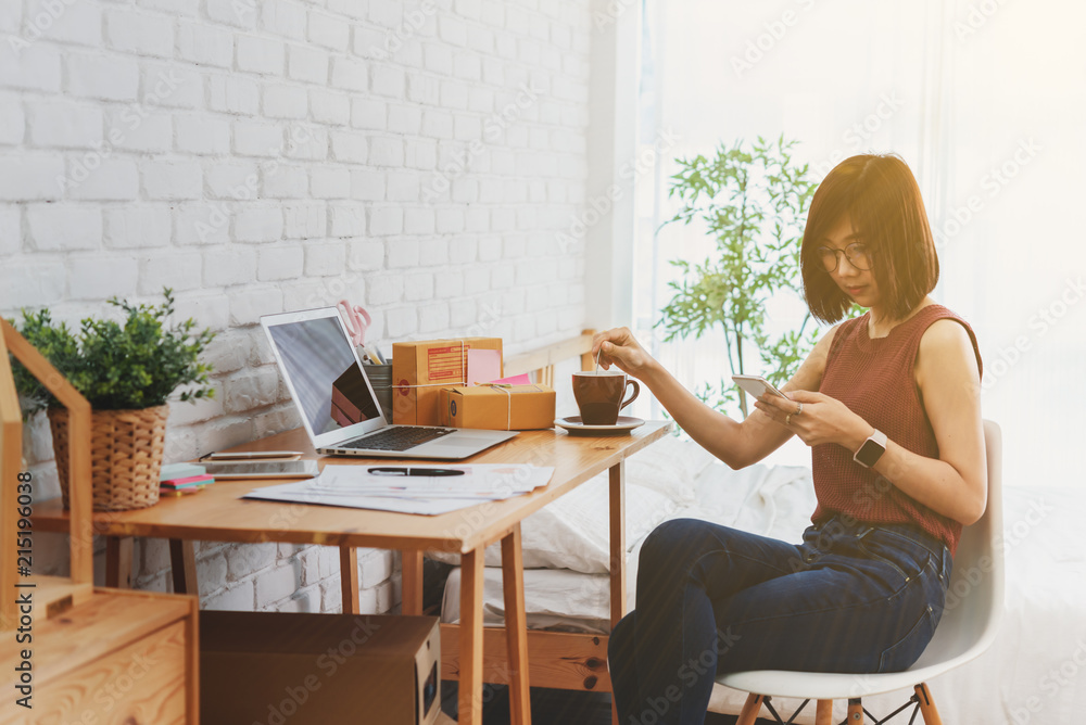 Woman small business owner, business start up conceptual, young entrepreneur use internet with smartphone during morning coffee Woman small business owner, business start up conceptual, young entrepreneur use internet with smartphone during morning coffee