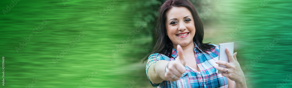 Portrait of happy young woman with thumbs up, outdoors Portrait of happy young woman with thumbs up, outdoors