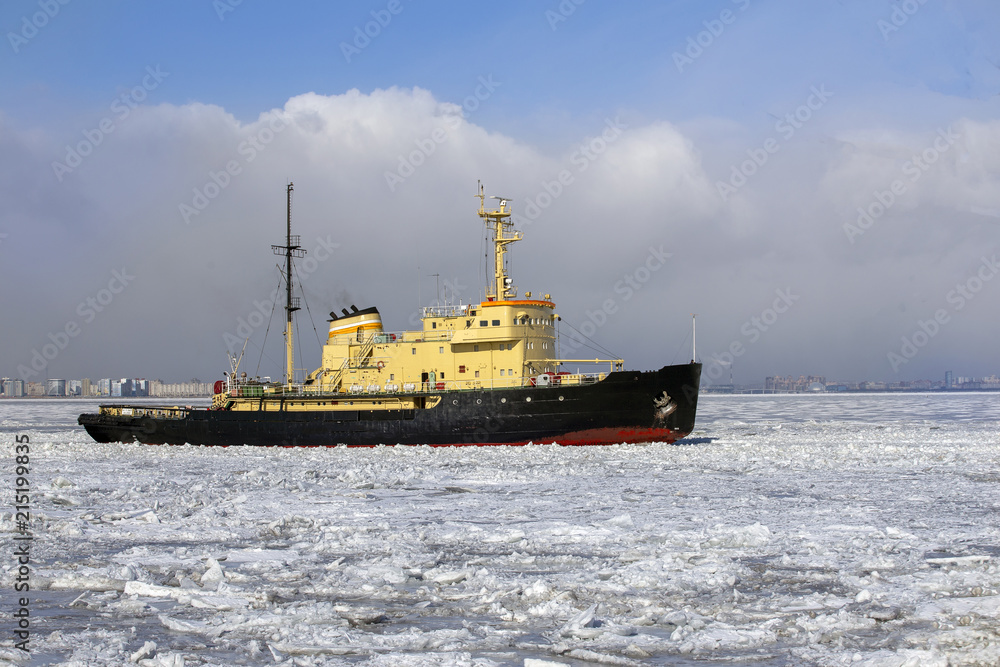Icebreaker ship breaks ice and moves across the frozen sea