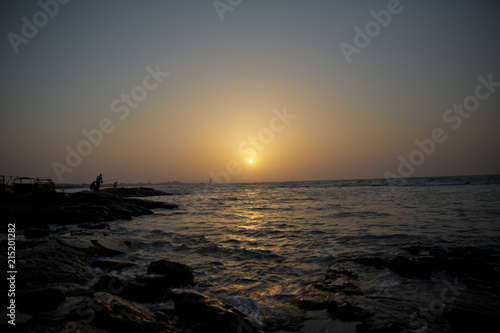 Beautiful sunset at the beach  amazing colors  light beam shining through the cloudscape. Azerbaijan sea and beach . The sound of the sea waves is coming . The fisherman fishes in the sea .