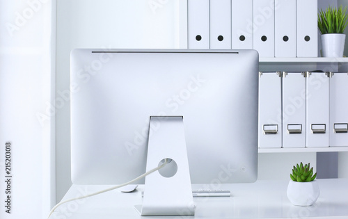 Office table with blank notepad and laptop