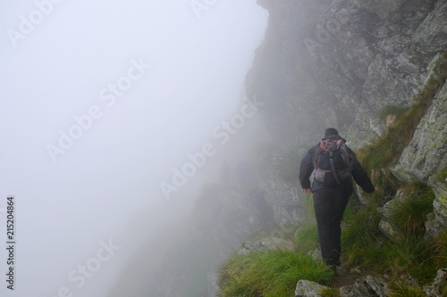 Fototapeta Naklejka Na Ścianę i Meble -  Rumunia, Karpaty Rumuńskie - Góry, Fagaras, turyści we mgle na czerwonym szlaku na szczyt Negoiu
