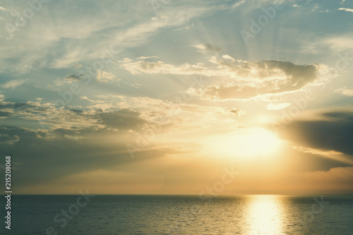 Sun rays through rain clouds over the sea