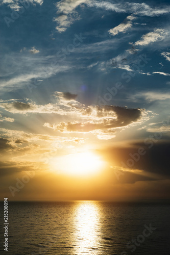 Dramatic red sunset over the sea with massive thunderclouds