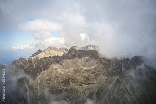 Hiking in the Tatra National Park Slovakia, Poland. Landscpes and panorama with mountain range.  Clouds and Fog around the hikers. photo