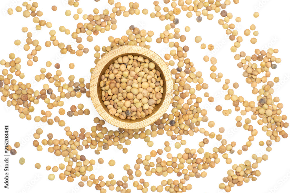 Lot of whole raw green lentil seeds in a wood bowl and around flatlay isolated on white Lot of whole raw green lentil seeds in a wood bowl and around flatlay isolated on white