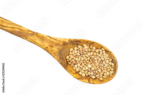 Lot of whole raw green lentil seeds in olive wood spoon flatlay isolated on white
