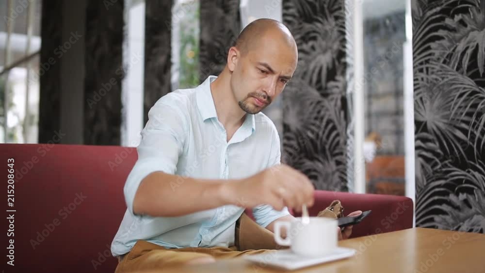 Young man with tablet computer drinking coffee in cafe Young man with tablet computer drinking coffee in cafe