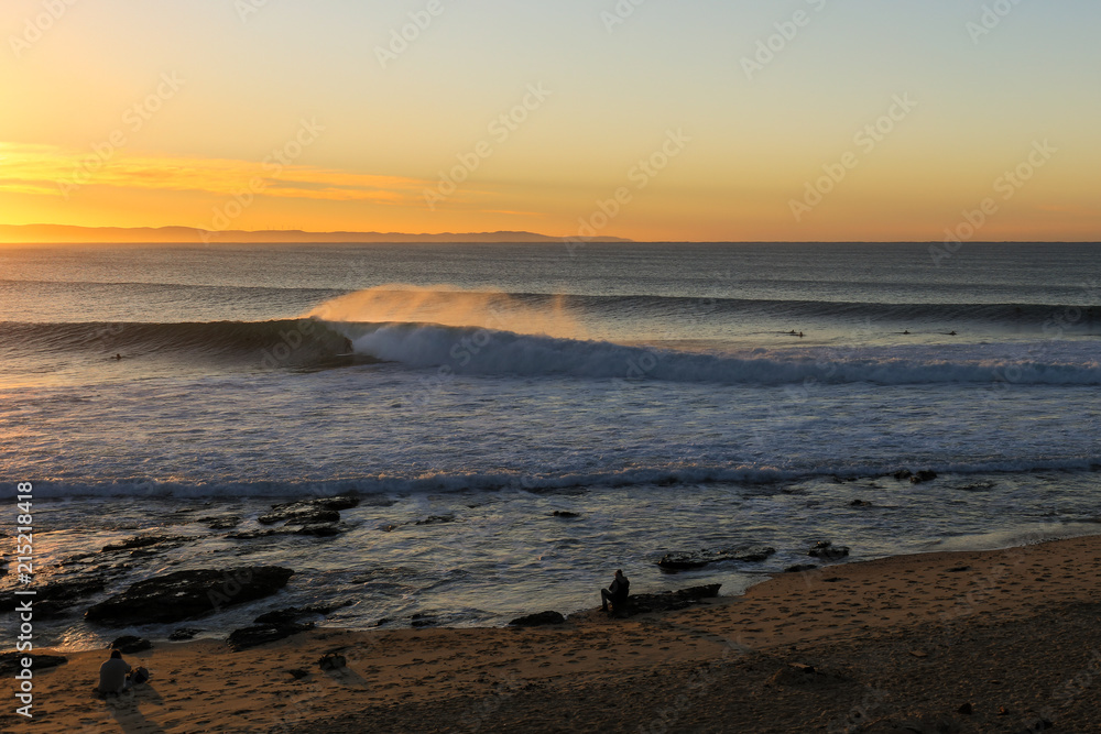 Seascape at sunrise with the waves rolling to the beach and a golden sky in the background Seascape at sunrise with the waves rolling to the beach and a golden sky in the background
