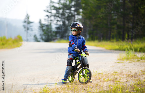 Happy boy having fun riding a bicycle with glasses, helmet, in defense © caxa75onohoi