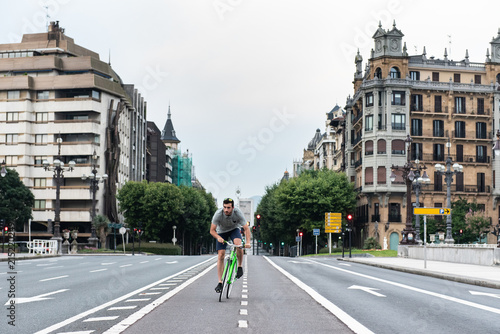 Man riding bike on road in town photo