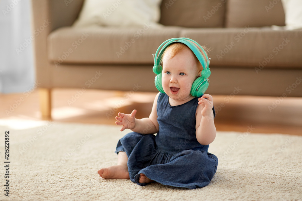childhood kids and technology concept lovely redhead baby girl in headphones listening to music at home Stock Photo Adobe Stock