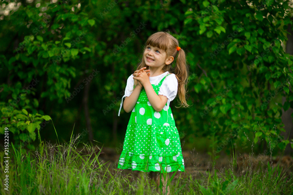 Little girl walk in green garden in sunny summer day Little girl walk in green garden in sunny summer day