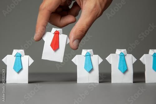 Choosing good employee leader. Man chooses and takes in the hand an employee in shirt and red tie. recruitment photo