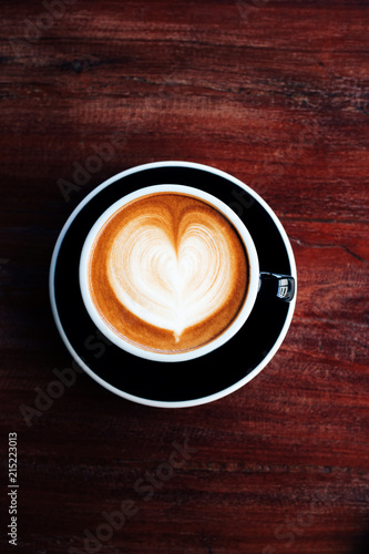 Cloase up coffee cup on wooden table in coffee shop.