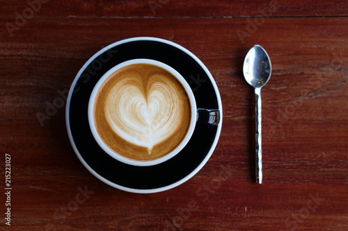 Fototapeta Cloase up coffee cup on wooden table in coffee shop.