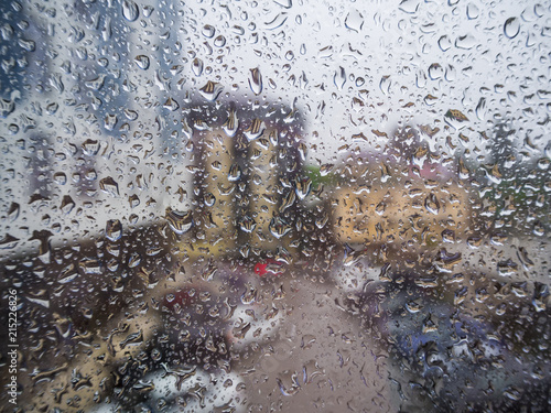 Fototapeta Naklejka Na Ścianę i Meble -  Glass in droplets from the rain in the background of the street yard
