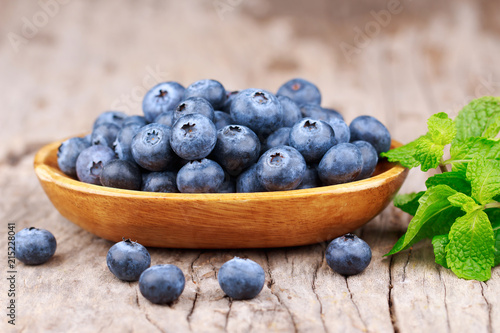 Blueberries in a wood bowl on a wooden table, Healthy eating and nutrition concept