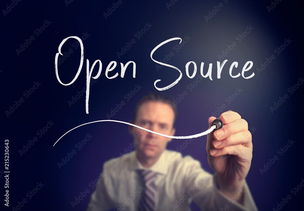 A businessman writing a open source concept with a white pen on a clear screen. A businessman writing a open source concept with a white pen on a clear screen.