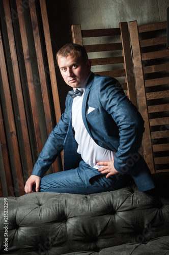 Luxury groom in a wedding suit in a beautiful interior room