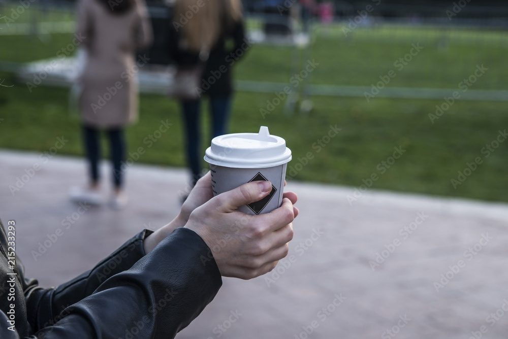 A disposable glass in the hands of a woman. Disposable paper cup for coffee, tea. A disposable glass in the hands of a woman. Disposable paper cup for coffee, tea.