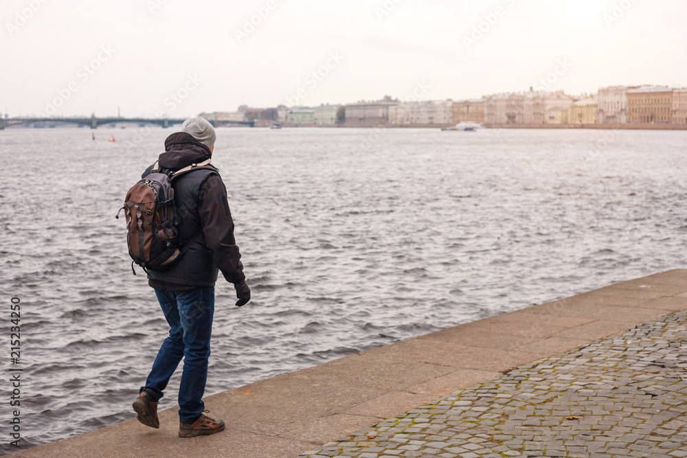 a man with a backpack is on the Neva river in St. Petersburg