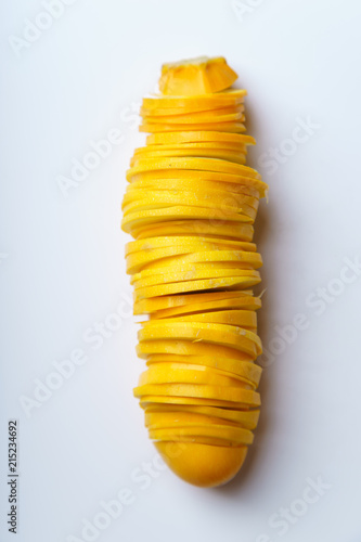 Top view of sliced summer yellow squash on white background