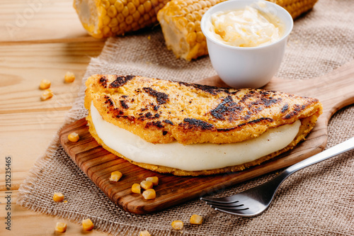 Wooden table with several ingredients for the preparation of Cachapas with cheese, corn, butter, ground corn and white cheese, Venezuelan Cuisine photo