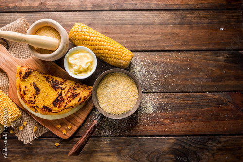 Typical Venezuelan cuisine, Top view of a wooden table with several ingredients for the preparation of Cachapas with cheese, corn, butter, ground corn and white cheese