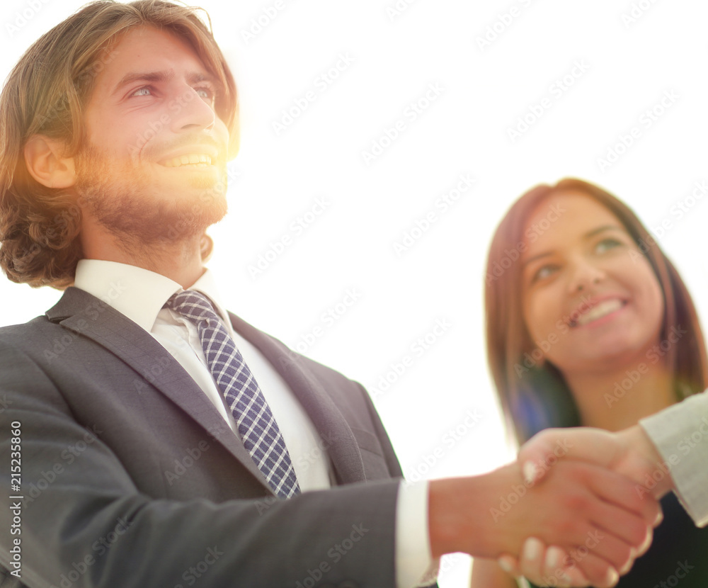Businesspeople shaking hands against room with large window loo Businesspeople shaking hands against room with large window loo