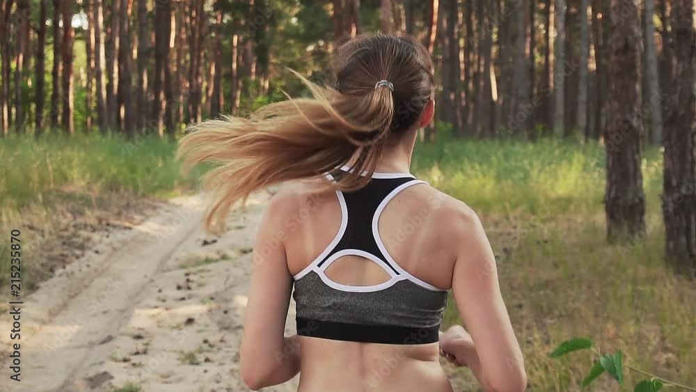 Slow motion of female athlete running on training in sportswear Slow motion of female athlete running on training in sportswear