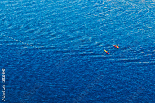 people kayaking in the blue sea view from the top