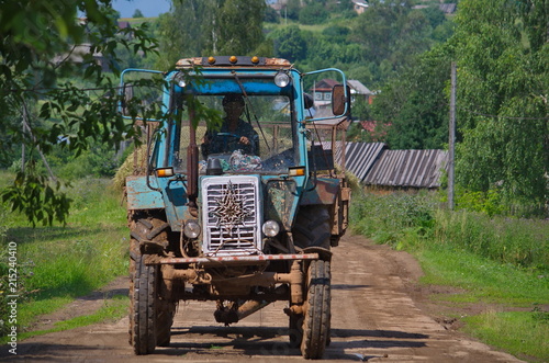 Tractor traveling with hay through the village