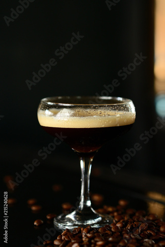 orange cocktail in a glass with ice on a dark background