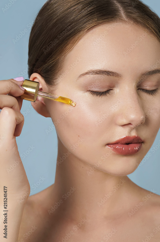 attractive young woman applying serum on her face . skin care concept attractive young woman applying serum on her face . skin care concept
