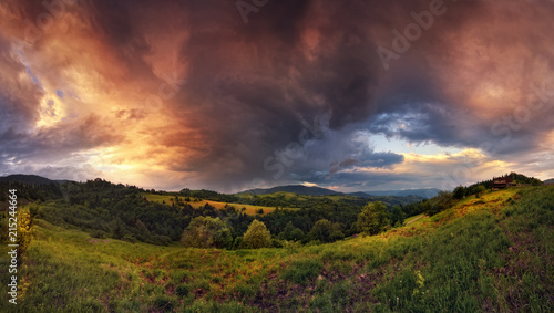 Thunderstorm In The Mountains. Panoramic Summer Landscape With Enchanting Stormy Sky  Storm Clouds  Sunny Valley And Small Rural House.Sunset-Sunrise Landscape With  Beautiful Sky.Stormy Weather.